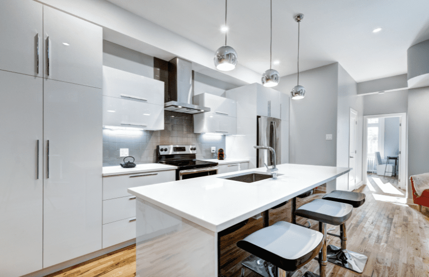 Modern kitchen renovation with white cabinets and wooden flooring