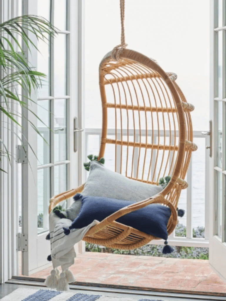 Stylish hanging wicker egg chair with blue cushion